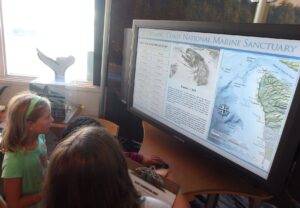 Olympic Coast Discovery Center Junior Oceanographers looking at ocean map